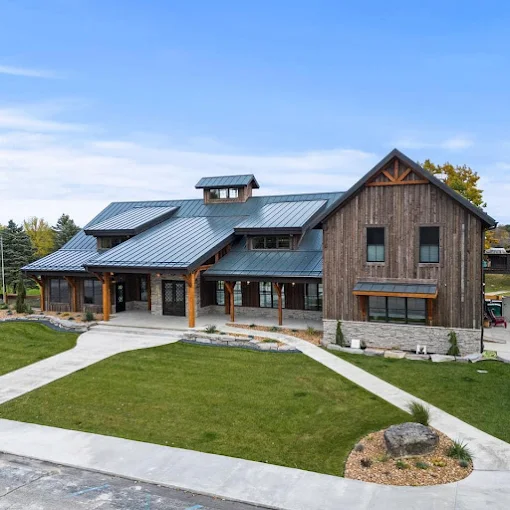 Rustic barn reception space at Revel Run decorated with greenery and soft lighting.