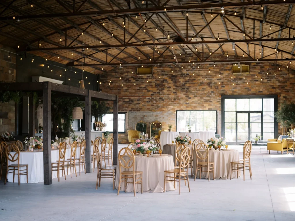 Industrial wedding venue interior at Millhaven with exposed brick and large factory windows.