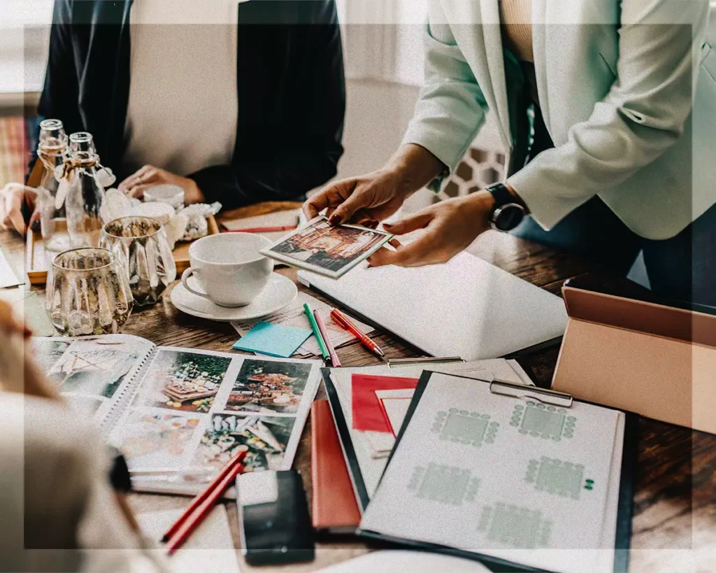 Wedding planner reviewing inspiration photos and planning details with couple during consultation meeting