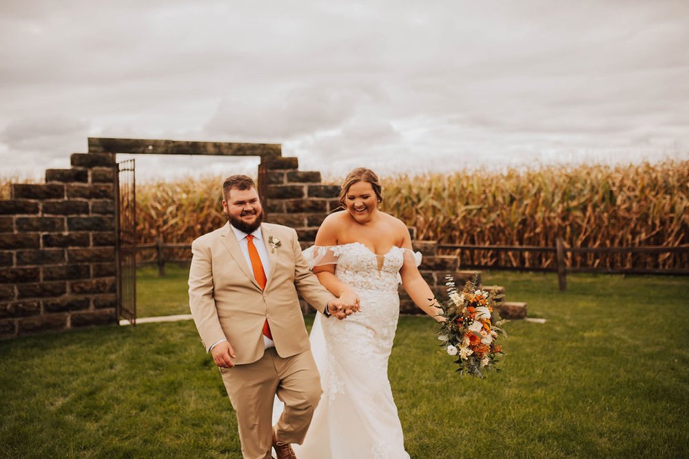 Bride and groom walking together after their outdoor fall wedding ceremony